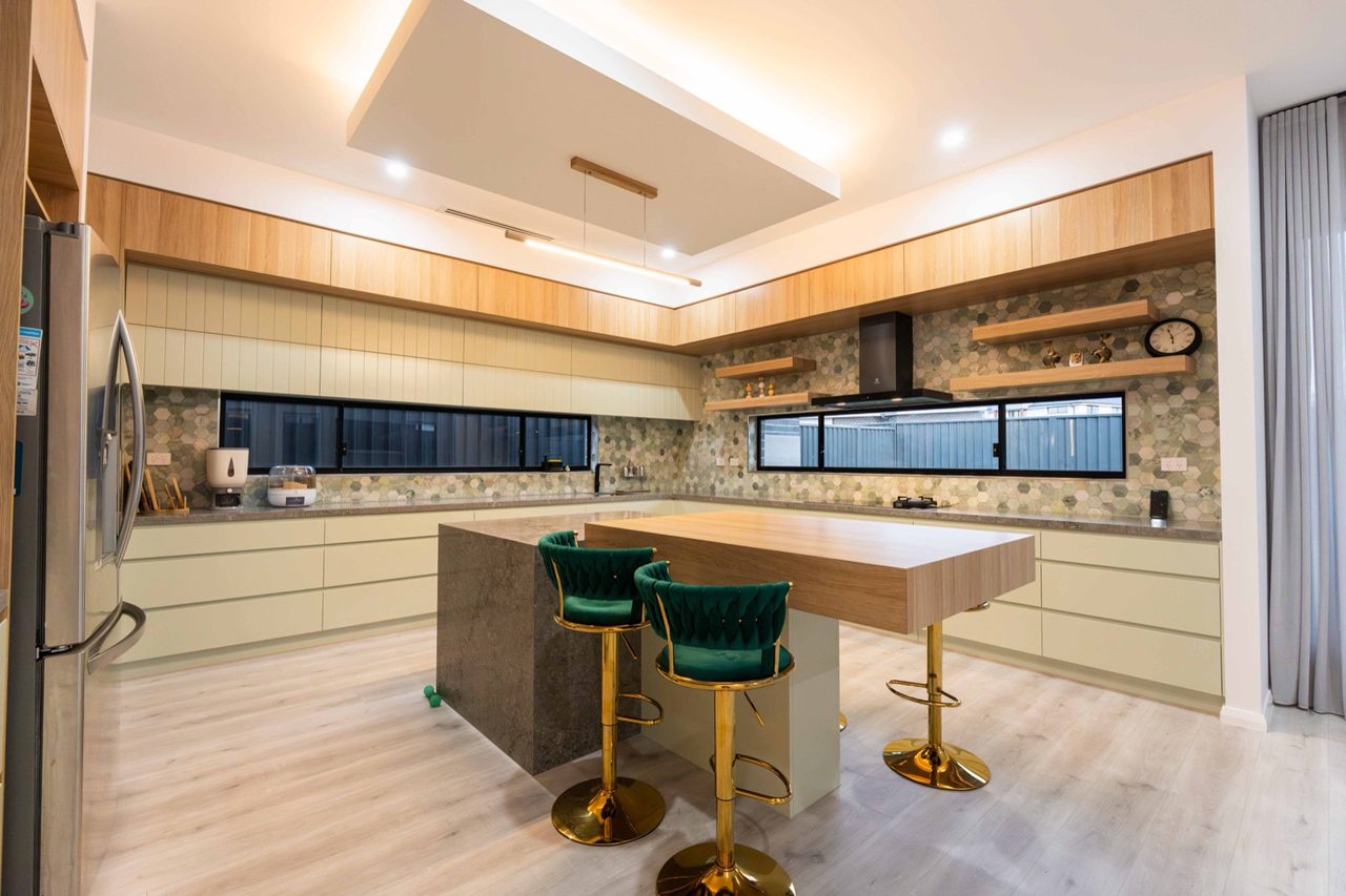 Warm timber kitchen with green seating in the Melonba project